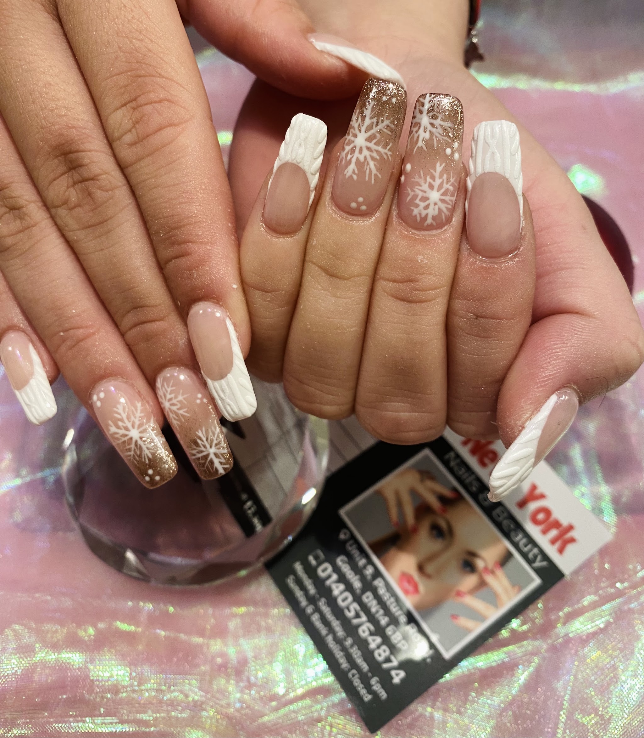 Nude and brown French nails with white snowflakes