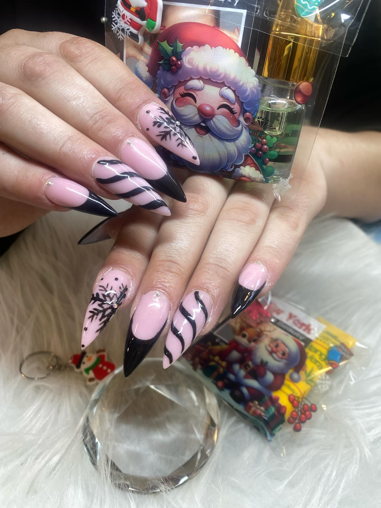 Pink and black striped stiletto nails with snowflake art